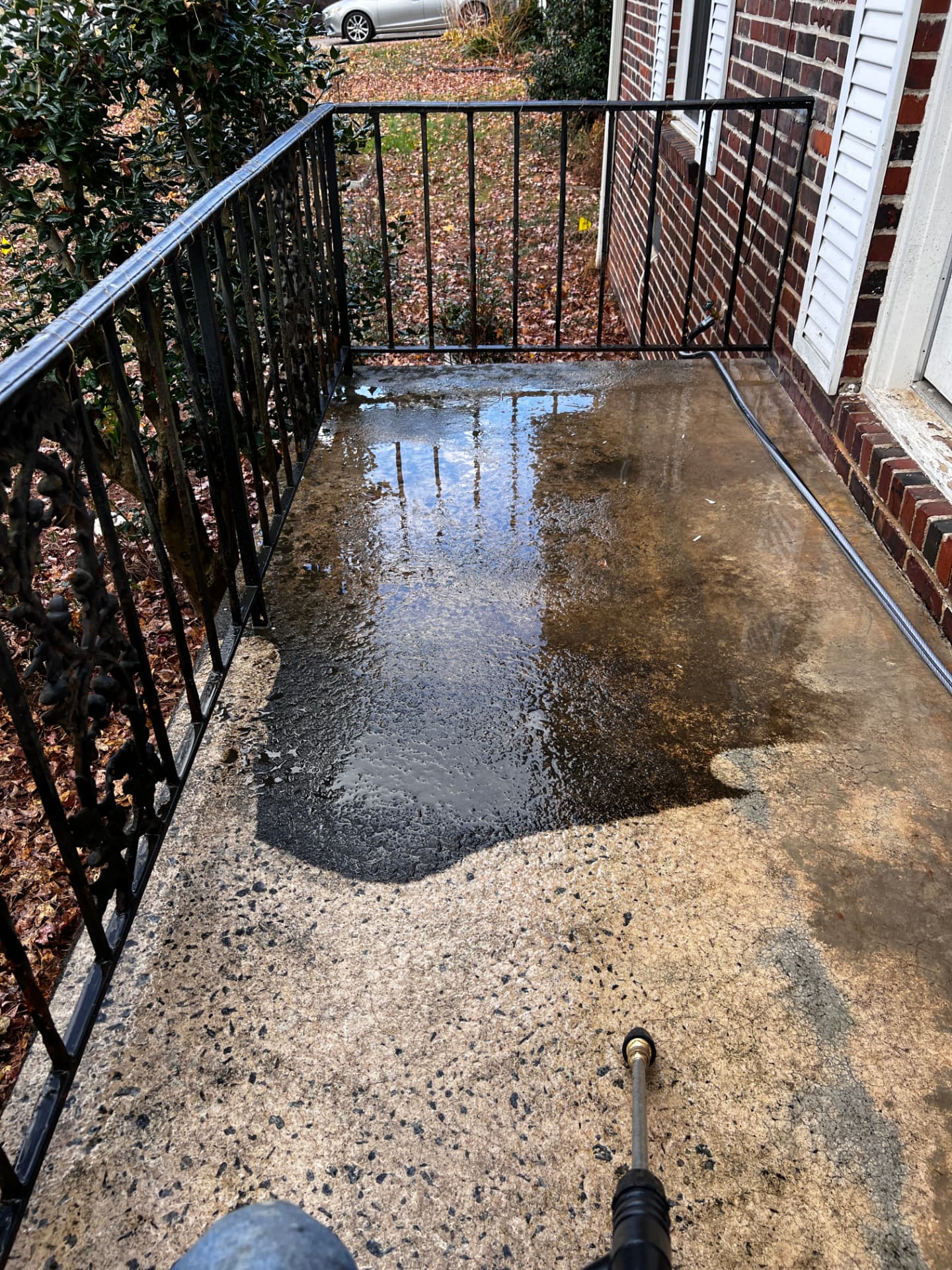 Concrete patio mid-clean showing the before and after contrast