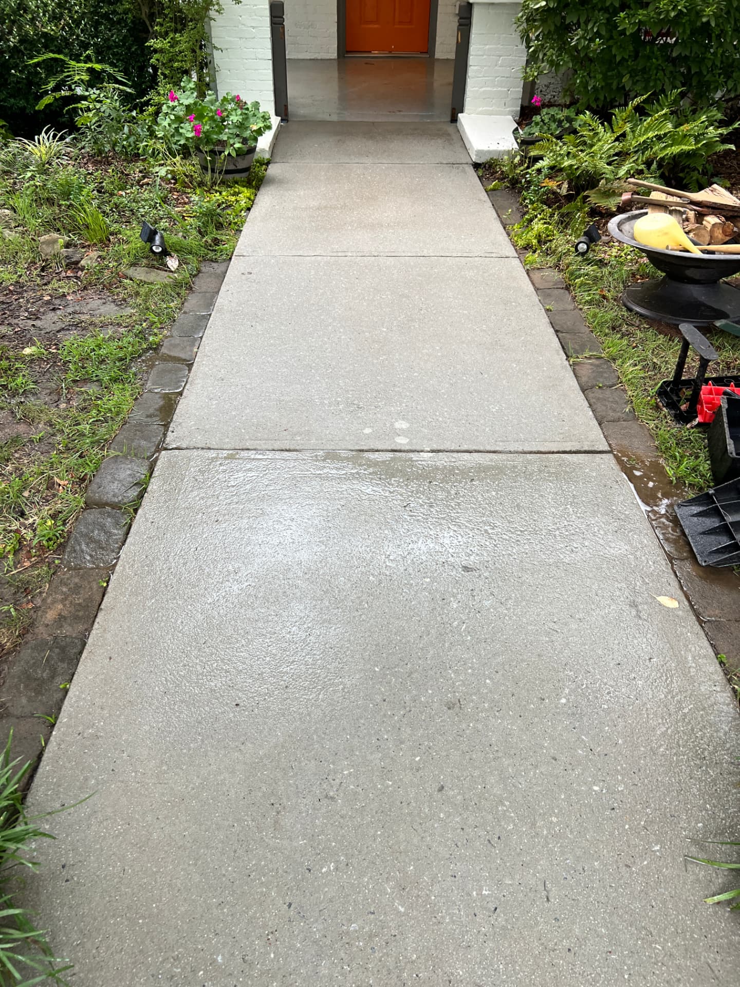 Freshly cleaned concrete walkway leading to a home
